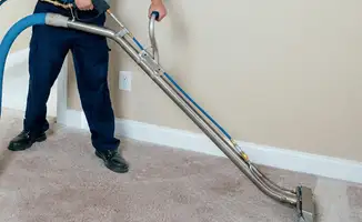 Professional operating a liquid removal machine on a carpeted floor in Los Angeles, CA